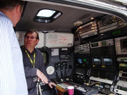 BBC engineer demonstrating how to operate the control console in an outside broadcast truck